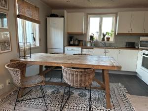 a kitchen with a large wooden table and chairs at Villa Tjurpannan Grebbestad in Grebbestad