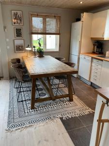 uma cozinha com uma mesa de madeira e algumas cadeiras em Villa Tjurpannan Grebbestad em Grebbestad