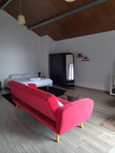 sala de estar con sofá rojo y cama en Apartamentos Porto de Abrigo, en São Vicente