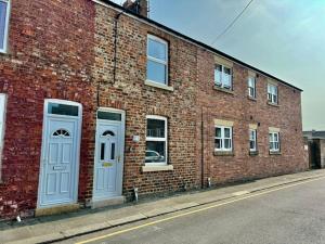 un edificio in mattoni con due porte e finestre blu di Walkers Row a Guisborough
