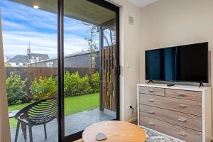 クライストチャーチにあるCitypad Studio Apartmentのリビングルーム(テレビ付)、ガラスのスライドドア