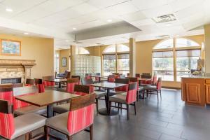 a restaurant with tables and chairs and a fireplace at Comfort Inn & Suites Chesapeake - Portsmouth in Chesapeake