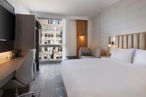 a hotel room with a large white bed and a window at Courtyard by Marriott New York Manhattan / Soho in New York