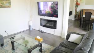 een woonkamer met een bank en een tv aan de muur bij Richview Gardens Suite in Toronto
