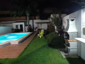 um quintal à noite com uma piscina em Villa Lolera em Chiclana de la Frontera