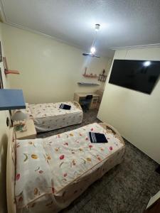 a room with two beds and a flat screen tv at Torrevieja Fantastico apto para familas numerosas Ada Purisima full equipado cerca a la playa del cura in Torrevieja +14 photos