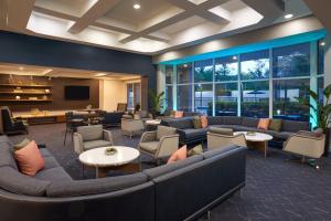 a lobby with couches and tables and a tv at Courtyard by Marriott Fort Lauderdale Weston in Weston