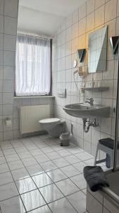 a white bathroom with a sink and a toilet at Bacharacher Hof in Bacharach