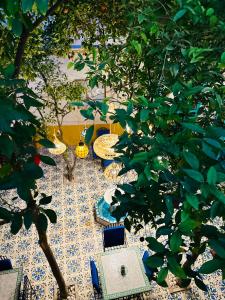 a table and chairs on a floor with trees at Riad Al Nour in Marrakech