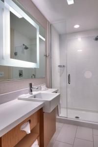 a white bathroom with a sink and a shower at SpringHill Suites Coeur d'Alene in Coeur d'Alene