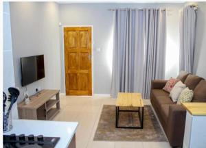 a living room with a couch and a table at Thito Manor Apartment in Maun