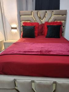 ein großes rotes Bett mit weißen Stühlen in einem Zimmer in der Unterkunft Aparta estudio en santiago #1 in Santiago de los Caballeros
