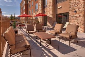 un gruppo di sedie, tavoli e ombrelloni su un patio di SpringHill Suites by Marriott Salt Lake City Downtown a Salt Lake City