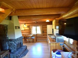 a kitchen with a stone fireplace in a log cabin at Holiday home in Kopalino in Kopalino
