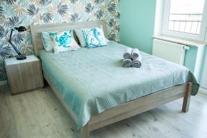 sypialnia z łóżkiem z butami w obiekcie Gwiazda Morska w Karwieńskim Błocie