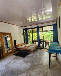 ein Schlafzimmer mit einem Bett in einem Zimmer mit Fenstern in der Unterkunft DS House in Cabuya