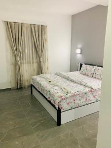 a bedroom with a bed with a floral bedspread at Hotel Albatros in Prizren