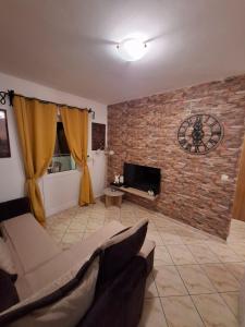 a living room with a couch and a brick wall at Apartman Muric in Rafailovici +23 photos