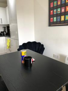 una mesa negra con una taza de café encima en Impeccable 2-Bed Apartment in Orpington, en Orpington