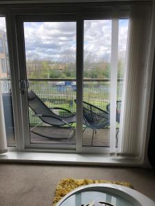 une porte coulissante en verre avec une chaise sur une terrasse couverte dans l'établissement Impeccable 2-Bed Apartment in Orpington, à Orpington