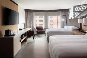 a hotel room with two beds and a television at Cincinnati Marriott at RiverCenter in Covington