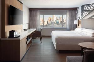 a hotel room with a bed and a large window at Cincinnati Marriott at RiverCenter in Covington