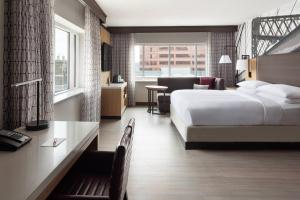 a hotel room with a bed and a desk and a room at Cincinnati Marriott at RiverCenter in Covington