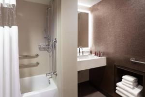 a bathroom with a sink and a tub and a toilet at Cincinnati Marriott at RiverCenter in Covington