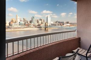 a balcony with chairs and a view of the river at Cincinnati Marriott at RiverCenter in Covington