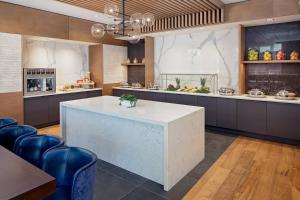 a large kitchen with a white counter and blue chairs at Cincinnati Marriott at RiverCenter in Covington