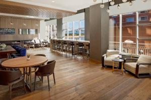 a restaurant with tables and chairs and a bar at Cincinnati Marriott at RiverCenter in Covington