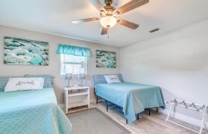 a bedroom with two beds and a ceiling fan at Crystal River Getaway with Dock, Kayaks and Bicycles! in Crystal River