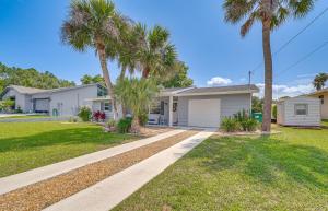 a house with palm trees in a yard at Crystal River Getaway with Dock, Kayaks and Bicycles! in Crystal River
