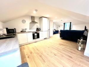 eine große Küche und ein Wohnzimmer mit Holzböden in der Unterkunft Maidstone City Centre Penthouse Apartment in Kent