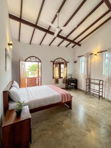 a large bedroom with a large bed and a desk at Light House View Inn - Galle Fort in Galle