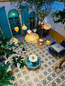 un patio con mesa y sillas en un suelo de baldosa en Riad Al Nour, en Marrakech