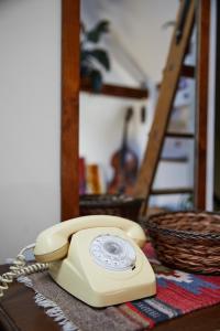 een gele telefoon op een tafel met een mand bij Cesar Apartment in Wrocław