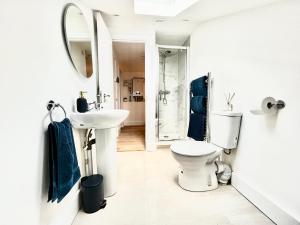 a white bathroom with a toilet and a sink at Maidstone City Centre Penthouse Apartment in Kent