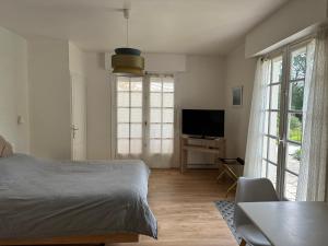 um quarto com uma cama e uma televisão de ecrã plano em Gîte de charme avec jolie vue em Saint-Lyphard