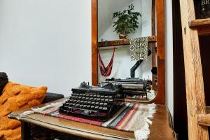 una vieja máquina de escribir sentada en una mesa frente a un espejo en Cesar Apartment, en Wroclaw