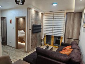 a living room with a couch and a bedroom at LUX Apartman AS - Montevia in Zlatibor