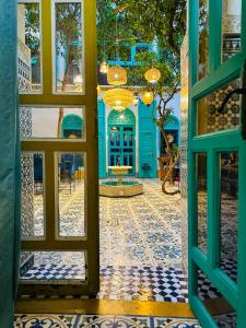 otwarte drzwi do budynku z podłogą wyłożoną kafelkami w obiekcie Riad Al Nour w Marakeszu