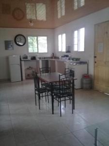 a kitchen with a table and chairs and a clock at Hotel Cabañas Casita La Ermita in San Carlos