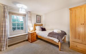 Кровать или кровати в номере Peacock Cottage