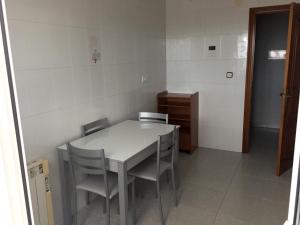 eine Küche mit einem Tisch und Stühlen im Zimmer in der Unterkunft Terraza de las Gaviotas in San Cosme de Barreiros
