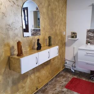 ein Bad mit einem Waschbecken und einem Wandspiegel in der Unterkunft Casa Tiron(Pai) in Gura Humorului