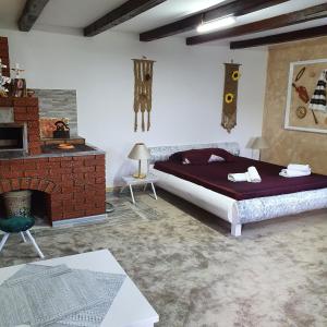a bedroom with a bed and a brick fireplace at Casa Tiron(Pai) in Gura Humorului