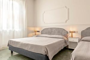 a bedroom with two beds and a mirror on the wall at The Port Residence in Livorno
