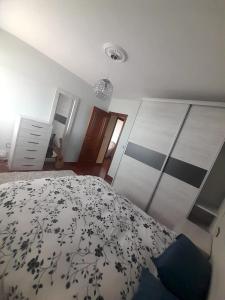 ein Schlafzimmer mit einem Bett mit einer schwarzen und weißen Decke in der Unterkunft Terraza de las Gaviotas in San Cosme de Barreiros