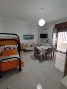 ein Wohnzimmer mit Etagenbetten und einem Tisch in der Unterkunft CASA CIELO in Favignana